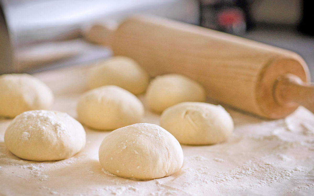 Bolledeig uten egg på et bakebord.