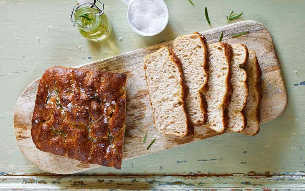 Oppskåret grov focaccia på en trefjøl.