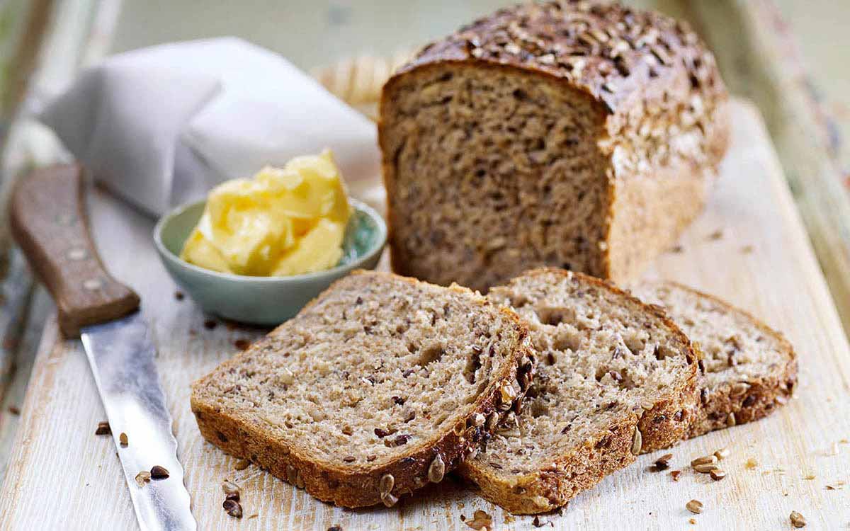 Oppskåret grovt matpakkebrød med smør.