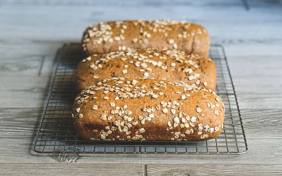 Tre nystekte havrebrød på en bakerist.