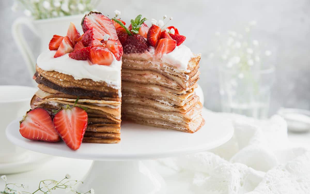 Pannekake kake med krem og friske jordbær på toppen.