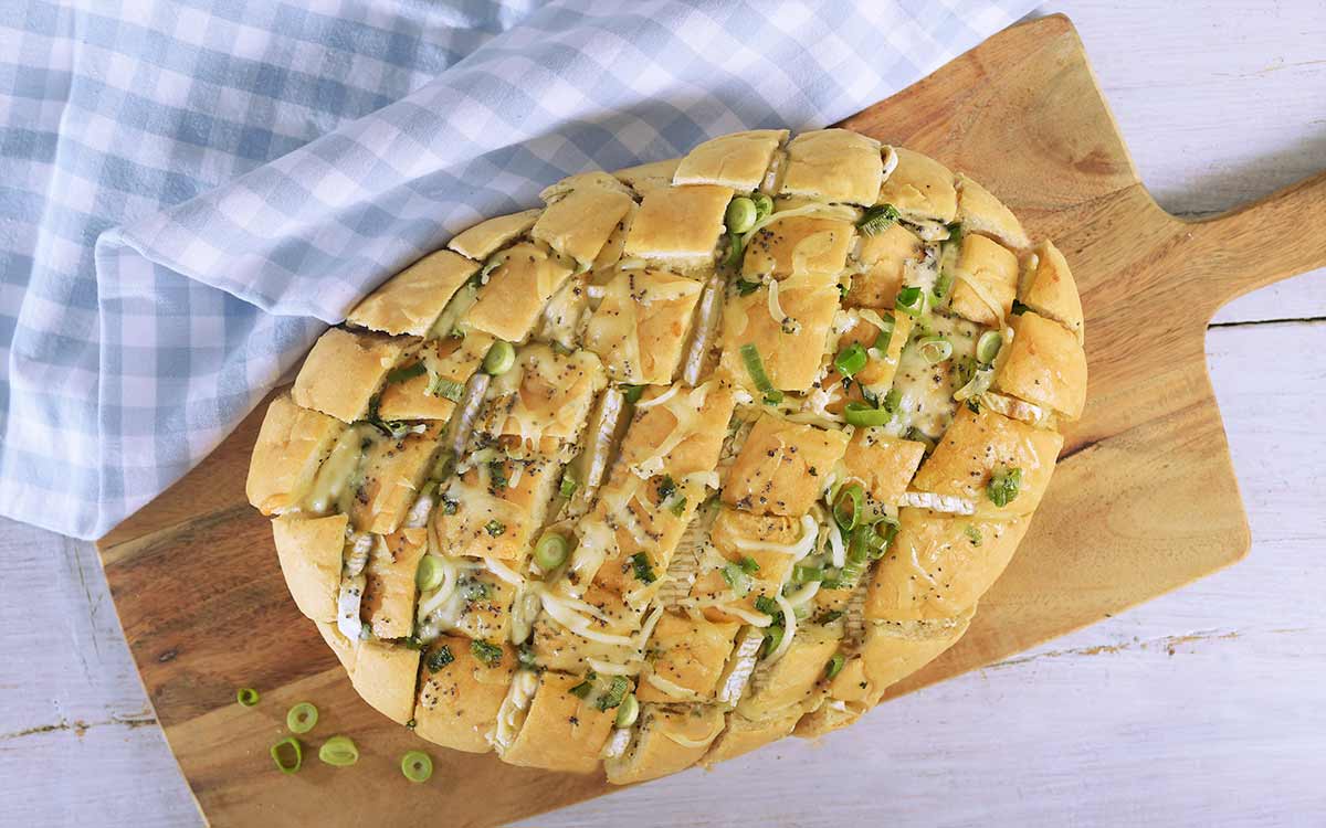 Nystekt pull apart brød med brie på en trefjøl.