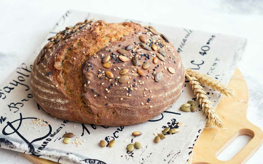 Hjemmebakt surdeigsbrød med solsikkefrø på toppen.