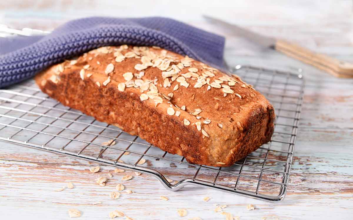 Hjemmebakt gluten og laktosefritt havrebrød på en bakerist.